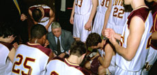 The men’s basketball team huddles around head coach Hernandez during a timeout in a recent game.