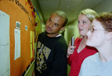 Percy Marchand (left) and Anna Hall (center) check out the run-off results late Tuesday as they were posted outside the Student Government Office. 