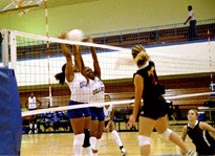 Education junior Amanda Gilliard spikes the ball into the Dillard defense as teammate Suzi Ruiz, history junior, looks on during a game at Dillard.