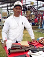 Richard Thomas proudly displays his carefully hand-crafted purses. Many of the prisoners at Angola sell their artwork to patrons, while keeping a portion of the profits for themselves. The selling of the crafts is an aside to the festivities.