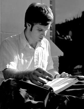 Joe Fredo, communications sophomore, reads one of his textbooks as he sits in the yard near the Monroe library.