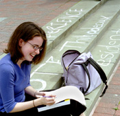 Sociology sophomore Erin Proven sits on the steps outside of the Monroe library computer lab, next to chalk advertisements that have become part of the steps.