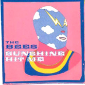 The cover of “Sunshine Hit Me,’ with a Mexican wrestler on a pink backround. The edges are faded, like on a record cover.