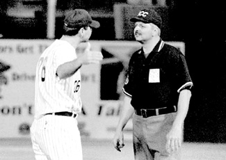 Loyola head coach Gregg Mucerino (left) argues with an umpire over a call by waving his hand and such.