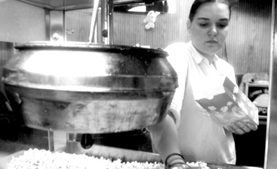 Katherine Phillips serves popcorn to moviegoers in the lobby. The theater is located at 5339 Prytania St. and is showing "The Passion of the Christ." 