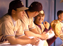Assistant baseball coach Brett Simpson (left) sits in the dugout during TuesdayÂ´s game against Mississippi College in the Superdome with finance freshman Marc Jaynes, who is pictured laughing.