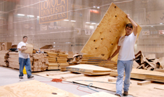 Sid Foret and Scott Bruitt stack plywood Wednesday afternoon as a part of the five man work force in charge of reconstructing the Wolf Den court floor.