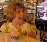 Four-year-old Katherine Curtis (above) enjoys her messy helping of BrocatoÂ´s strawberry ice cream. Curtis said the shop was her Â´favoritest.Â´ Employee Chris Senac, business finance sophomore, (bottom right) scoops up a hefty serving for customers Wednesday evening.