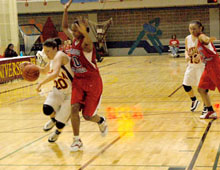 Criminal justice junior Dani Holland drives past Tougaloo defenders in the final home game of the regular season.