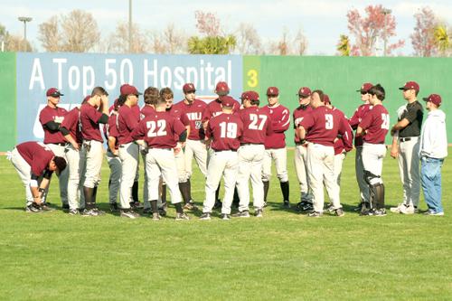 The baseball team gathers in the outfield after the first game of their double-header against Belhaven College. The team is 9-27 in the league and 6-17 in conference.