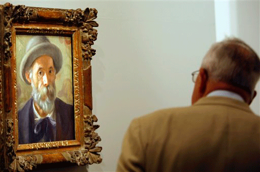 A visitor looks at "Autoportrait", (Self-portrait), an oil on canvas by French painter Pierre-Auguste Renoir, seen at the Grand Palais, in Paris, Tuesday, Sept. 22, 2009, as part of the "Renoir in twentieth-century" exhibition running from Sept. 23 untill Jan. 4, 2010