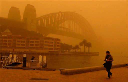 A man walks to work past an almost unseen Sydney Harbour Bridge during a dust storm Wednesday, Sept. 23, 2009 in Sydney, Australia.Flights are diverted and ferries canceled as a blanket of red dust shrouded most of Sydney after the weather system moved in from central Australia.