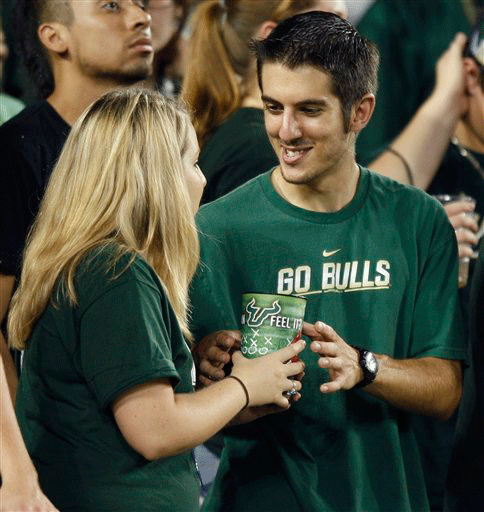 Two University of South Florida students take turns drinking from a cup during a college football game Saturday Sept. 19, 2009 in Tampa, Fla. Swine flu is swirling through the nation's campuses, but despite all the warnings, flu kits and prominently displayed jugs of hand sanitizer, many students just aren't that worried.