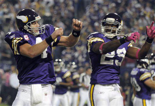 Minnesota Vikings' Brett Favre (4) celebrates with Chester Taylor (29) after Favre threw a touchdown pass during the first half of an NFL football game against the Green Bay Packers Monday, Oct. 5, 2009, in Minneapolis.