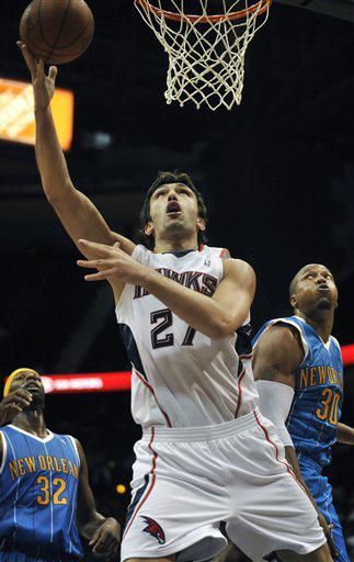 Atlanta Hawks center Zaza Pachulia (27, of Georgia, takes a shot against New Orleans Hornets forwards Julian Wright (32) and David West (30) during the first quarter of an NBA preseason basketball game at Philips Arena, Wednesday, Oct. 7, 2009, in Atlanta.
