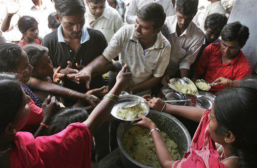 Residents crowd for food being distributed by a non-governmental organization in flood affected Chickmanchal village, some 340 miles (550 kilometers) north of Bangalore, India, Thursday, Oct. 8, 2009. Thousands among the legions of southern Indians displaced by a week of flooding trickled back to their homes and farms to survey the damage left by a natural disaster, officials said Wednesday.