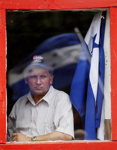 A supporter of Honduras' ousted President Manuel Zelaya looks through a window during a pro-Zelaya demonstration in Tegucigalpa, Tuesday, Oct. 6, 2009