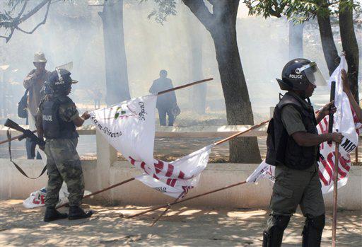 Clouds of tear gas pass over police, during a demonstration, in Antananarivo, Madagascar, Tuesday, Oct. 6, 2009. Police have dispersed protesters with tear gas outside a meeting of mediators who hope to smooth over Madagascar's post-coup political turmoil. 