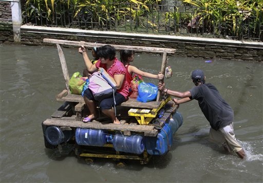 A man pushes his cart fitted with empty water container to serve as a floater in flood waters Saturday, Oct. 17, 2009 in suburban Pasig City east of Manila, Philippines. The governor of a northern Philippine province said Saturday he has ordered residents to evacuate their already storm-ravaged areas ahead of a new typhoon after back-to-back storms in recent weeks. 
