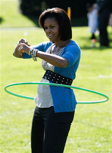 First lady Michelle Obama exercises with a hula hoop during a healthy kids fair on the South Lawn of the White House in Washington, Wednesday, Oct. 21, 2009.