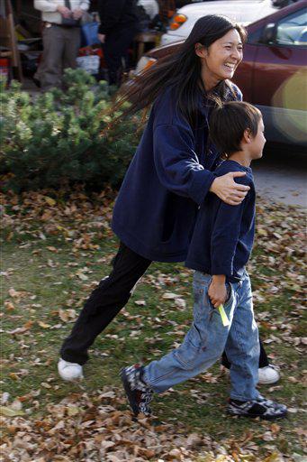 FILE - In this Oct. 15, 2009 file photo, Falcon Heene, 6, front, is guided back to a news conference by his mother, Mayumi, outside the family's home in Fort Collins, Colo..
