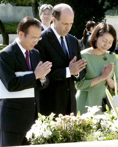 FILE - In this Oct. 4, 2009 file photo, U.S. Ambassador to Japan John Roos, center, and Hiroshima Mayor Tadatoshi Akiba, left, pray for the victims of the atomic bombing at the Memorial Cenotaph for A-Bomb Victims at Peace Memorial Park in Hiroshima, western Japan