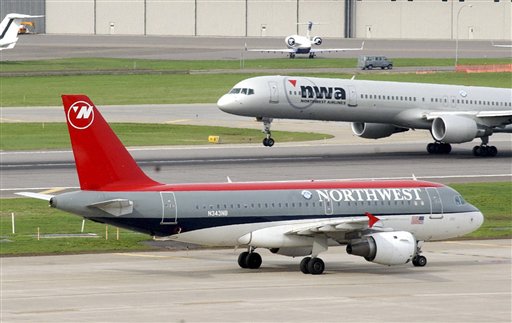 FILE In this Thursday, April 21, 2005 file photo, a Northwest Airlines plane taxis as another lifts off at Minneapolis-St. Paul International Airport, in Minneapolis. The two Northwest Airlines pilots should have had numerous warnings that their flight was nearing its destination in Minneapolis. Controllers were trying to reach the plane by radio, Wednesday, Oct. 21, 2009.