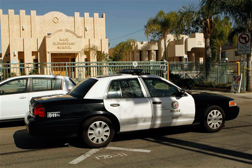 A Los Angeles Police patrol car is shown at the entrance of the Adat Yeshurun Valley Sephardic Orthodox synagogue where a gunman shot and wounded two men Thursday Oct. 29, 2009 in Los Angeles.