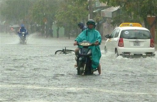 A motorcyclist goes through flooded water on Nguyen Thien Thuat street in Nha Trang city, a central south coast city in Vietnam, Tuesday, Nov. 3, 2009. Tropical Storm Mirinae unleashed severe flooding in parts of central Vietnam, killing about two dozens of people and stranding families on rooftops, disaster officials said Tuesday.