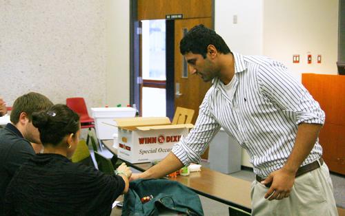 Mohammad Iqbal, finance sophomore and co-president of College Republicans, hands out papers to students at the first meeting of College Republicans Tuesday, Nov. 3.
