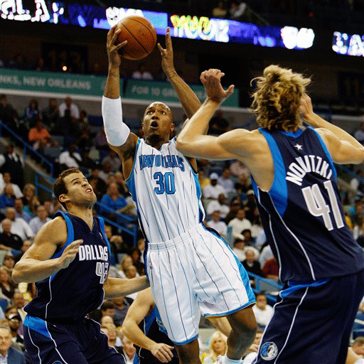 New Orleans Hornets forward David West (30) drives to the basket between Dallas Mavericks forward Dirk Nowitzki (41) and forward Kris Humphries (43) in the first half of an NBA basketball game in New Orleans, Wednesday, Nov. 4, 2009.