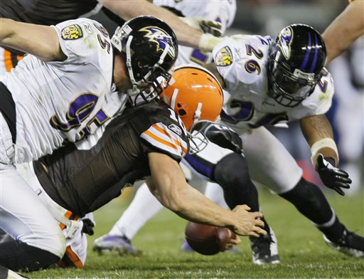 Cleveland Browns quarterback Brady Quinn recovers his own fumble as Baltimore Ravens linebacker Jarret Johnson (95) and safety Dawan Landry (26) converge in the fourth quarter of an NFL football game Monday, Nov. 16, 2009, in Cleveland. The Browns lost 16-0.