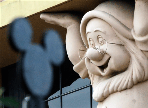 A smiling Doc, one of the Seven Dwarfs from the 1930s Disney classic animated feature, is seen on a building behind a stylized Mickey Mouse figure on a fence at Walt Disney Co. corporate headquarters in Burbank, Calif., Thursday, Nov. 12, 2009. The Walt Disney Co. on Thursday posted a surprise 18 percent increase in fourth-quarter earnings as its movie studio recovered from a lengthy downturn.