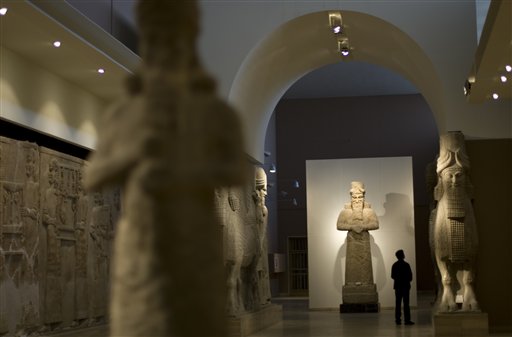 A journalist looks at an Assyrian statue, at Iraq's national museum, in Baghdad, on Tuesday, Nov. 24, 2009. Google is documenting the treasures of Iraq's national museum, home to priceless artifacts from the Stone Age through Islamic periods, and will make the photographs available online early next year, the company's chairman said Tuesday