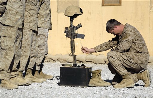 In this picture taken Monday, Nov. 9, 2009, a U.S. special operations member pays his final respects for a comrade killed on Saturday in Afghanistan's Farah province. President Barack Obama rejected the Afghanistan war options before him and asked for revisions, administration officials say, amid an argument by his own ambassador in Kabul that a significant U.S. troop increase would only prop up a weak, corruption-tainted government.
