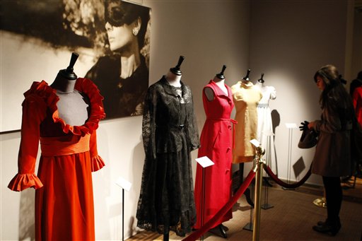 A visitor looks at dresses worn by Audrey Hepburn, including the outfit in black lace, second left, that she wore in the 1966 film "How to Steal a Million", exhibited amongst dozens of garments and personal items once belonging to the Hollywood star, in Paris, Tuesday Dec. 1, 2009, prior to a auction in London on Dec. 8.