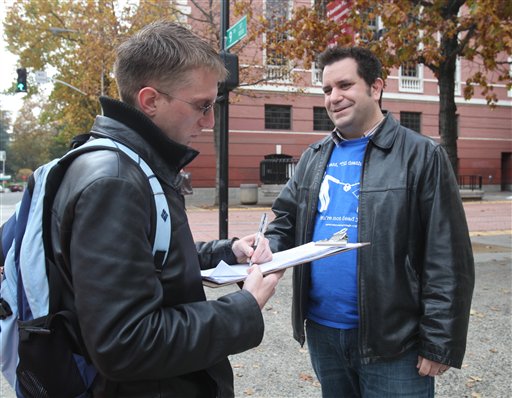 In this photo taken Saturday, Nov. 21, 2009, John Marcotte discusses his proposed initiative to ban divorce as Ryan Platt, left, signs the petition to get the measure on the ballot, in Sacramento, Calif. Marcotte is using the state's voter initiative process to make a satirical statement about the fight over gay marriage and voter approved 2008 Proposition 8 that banned gay marriage. Platt said he signed the petition in support of his lesbian sister.
