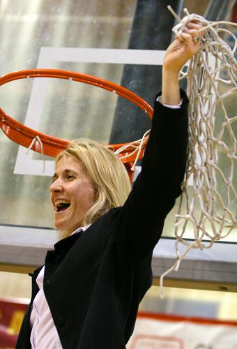 Kellie Kennedy, women’s head basketball coach, holds the net high in triumph after winning the GCAC Championship March 9.