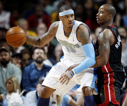 Denver Nuggets forward Carmelo Anthony, left, works the ball inside against Miami Heat guard Quetin Richardson in the first quarter of an NBA basketball game in Denver on Thursday, Dec. 3, 2009.