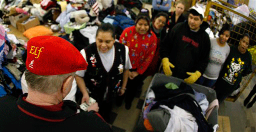 Wearing an "Elf" hat, the Kansas City Secret Santa distributes $100 bills to people at a Kansas City, Kan. thrift store Wednesday, Dec. 9, 2009.