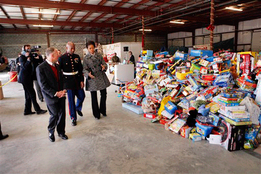 First lady Michelle Obama walks with Toys for Tots Chief Executive Officer Pete Osman, left, and Col. Danny Choike, Commanding Officer Quantico Marine Base, after delivering Christmas toys from White House staff at the Toys For Tots Stafford County Distribution Center in Stafford, Va., Wednesday, Dec. 16, 2009.