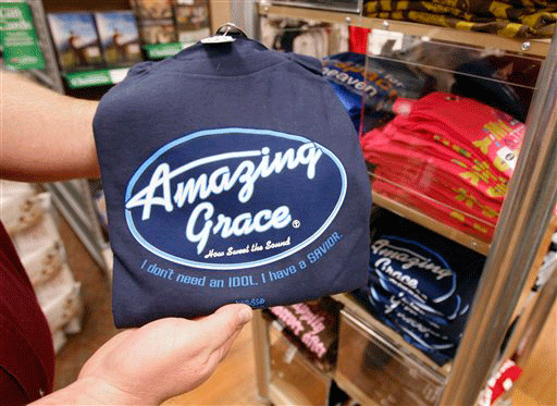 In this photo made Thursday, Dec. 10, 2009, Matt Jaggers, the manager of the Lifeway Christian Store in Nashville, Tenn., holds up a shirt which has the phrase"Amazing Grace" in the likeness of the logo for the popular television show "American Idol." The design is one of many used by the Kerusso company that parodies logos of popular products and television shows.