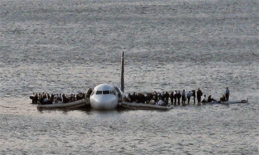 FILE - In this file photo from Jan. 15, 2009, airline passengers wait to be rescued on the wings of a US Airways Airbus 320 jetliner that safely ditched in the frigid waters of the Hudson River in New York, after a flock of birds knocked out both its engines.