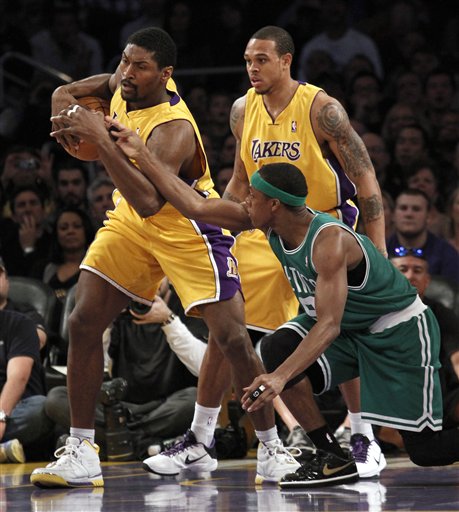 Los Angeles Lakers forward Ron Artest , left, takes the ball from Boston Celtics guard Rajon Rondo, right, as Los Angeles Lakers guard Shannon Brown, back, looks on during the first half of their NBA basketball game, Thursday, Feb. 18, 2009, in Los Angeles.