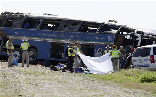 Arizona Department of Public Safety police officers and members of the medical examiner's office remove bodies from the site of a tour bus crash on Friday, March 5, 2010, in Sacaton, Ariz. Police are saying six people were killed in the crash on Interstate 10 about 25 miles south of Phoenix after a bus traveling from Mexico to Los Angeles struck a pickup truck and rolled before landing upright on its wheels. 