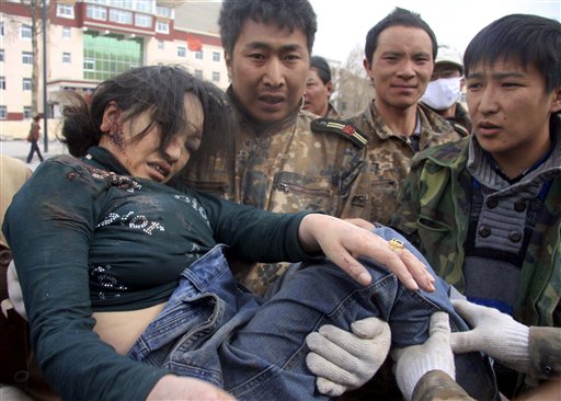 In this photo released by China's Xinhua News Agency, an injured woman is rescued after a quake in Yushu County, northwest China's Qinghai Province, Wednesday, April 14, 2010. A series of strong earthquakes struck a mountainous Tibetan area of western China on Wednesday, killing hundreds of people and injuring more than 10,000 as houses made of mud and wood collapsed, officials said.