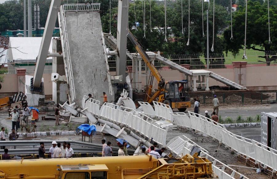 Indian workers remove debris of the collapsed bridge near Jawaharlal Nehru stadium in New Delhi, India, Tuesday, Sept. 21, 2010. A footbridge under construction near the Commonwealth Games main stadium collapsed on Tuesday, injuring people. The games are scheduled to be held from Oct. 3-14.
