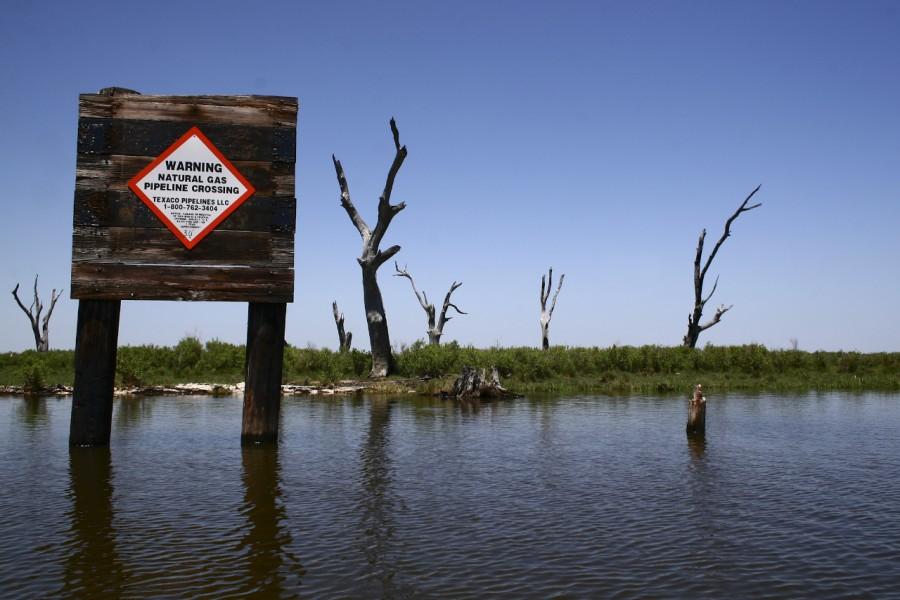 A sign warns boats of the natural gas pipeline beneath the water in Pointe aux Chenes, Louisiana. 