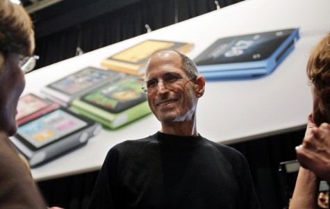 Apple CEO Steve Jobs smiles in front of an iPod Shuffle poster, Wednesday, Sept. 1, 2010, in San Francisco.