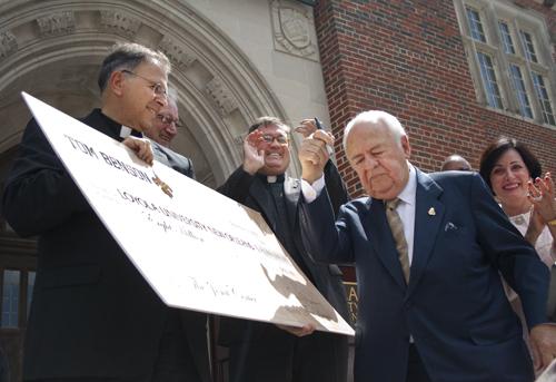 The Rev. Ted Dziak, S.J. holds a check for $8 million from Tom Benson, New Orleans Saints’ owner. The ceremony, Thursday Sept. 23 revealed that the donation is for renovating the old library.